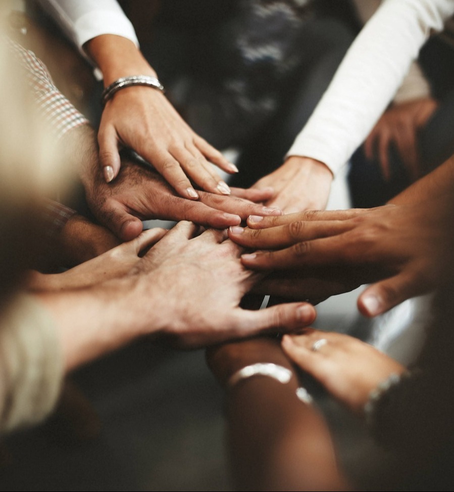 Diverse set of friends, putting hands in center on top of each other-1-1