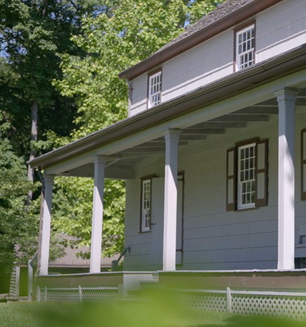 Side view of Quaker meeting house with plants blurred in foreground