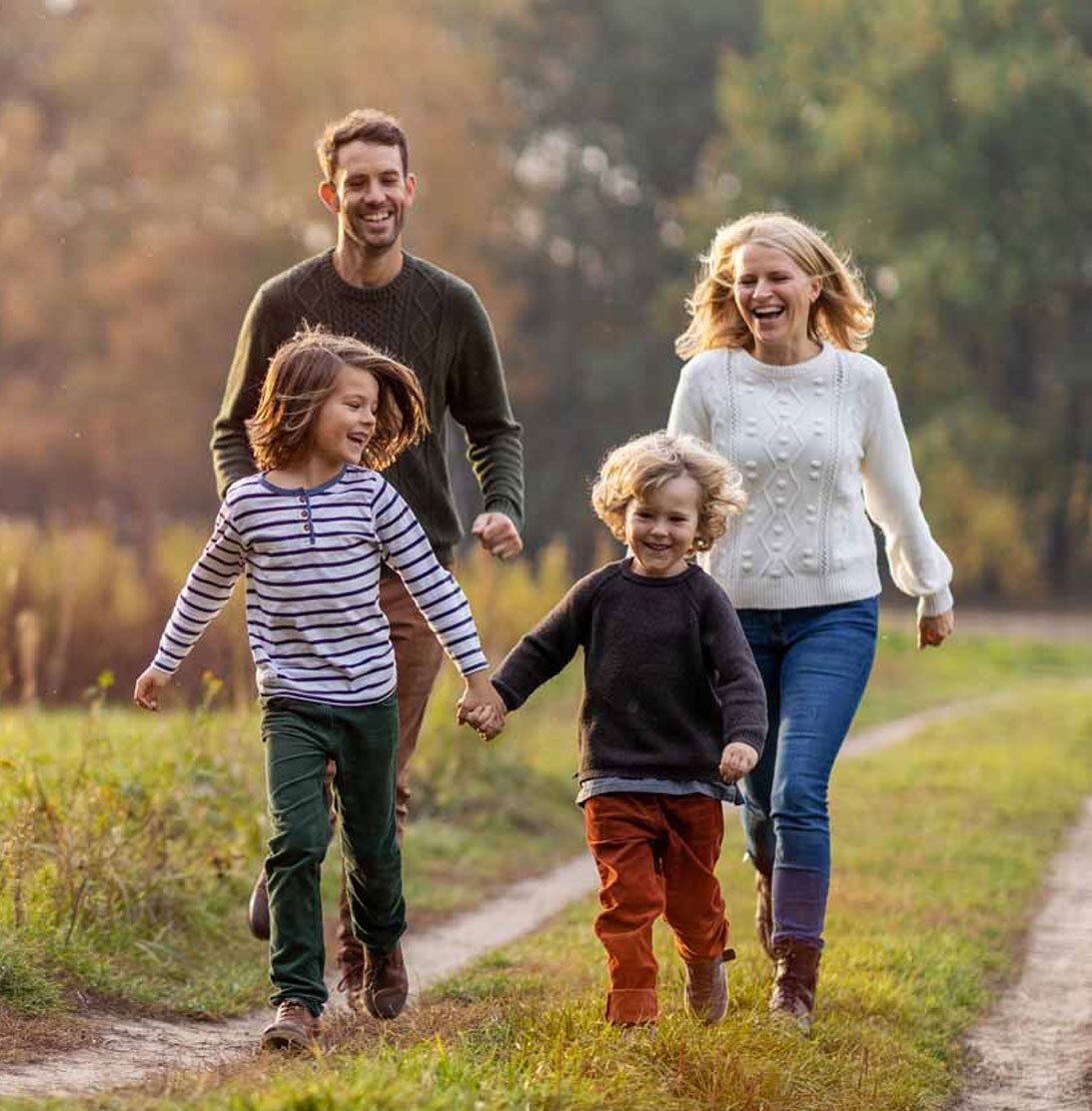 happy-family-of-four-walking-down-path