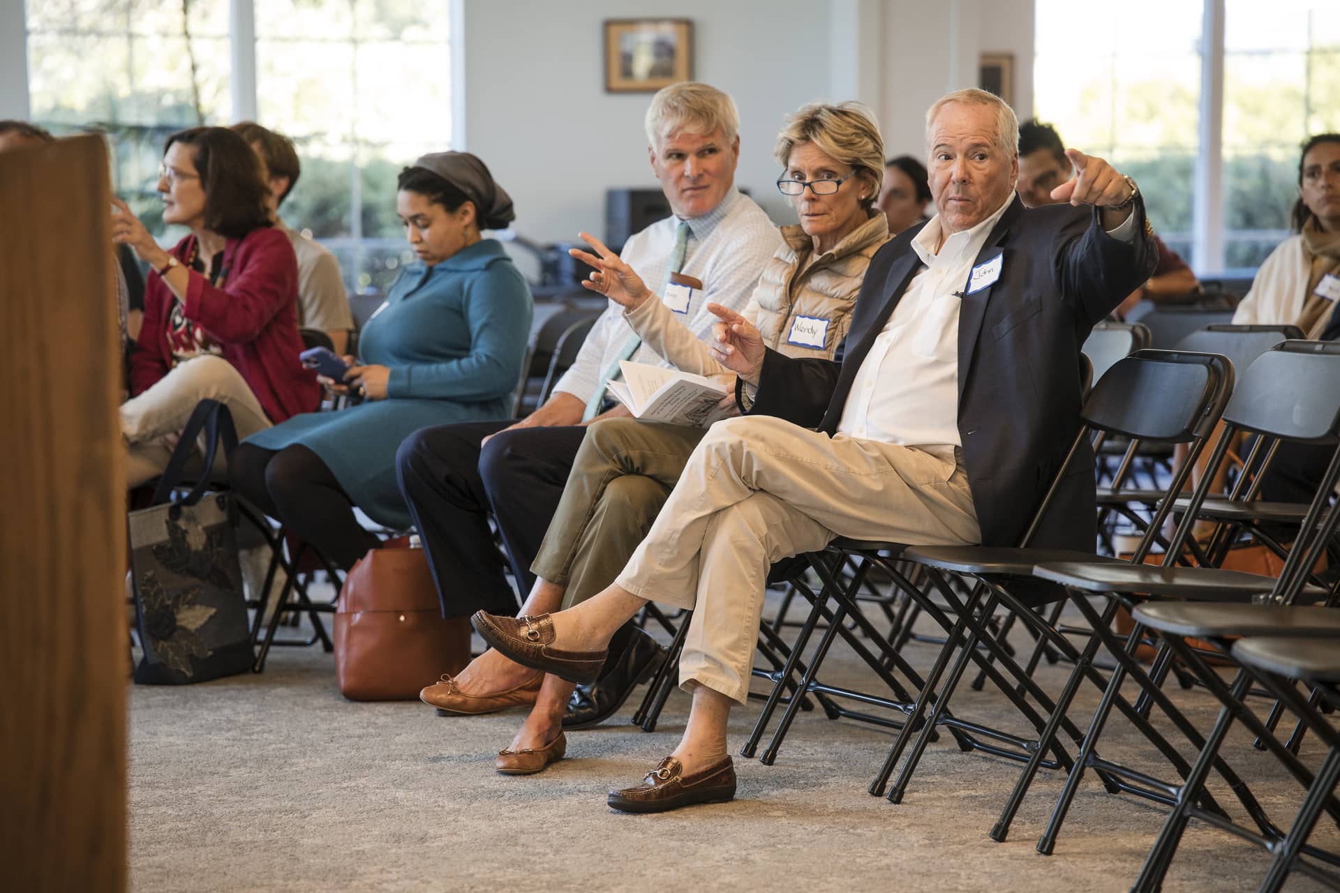 Attendees sitting in chairs waiting for presentation