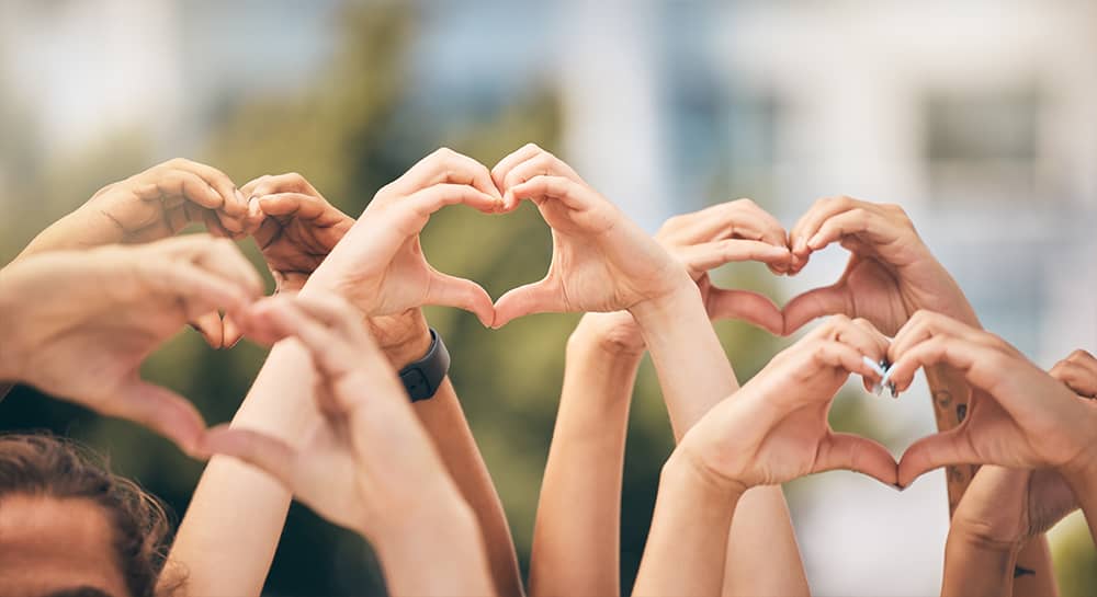 Groups of people with heart hands in the air